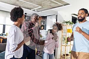 Family singing karaoke with microphones at home