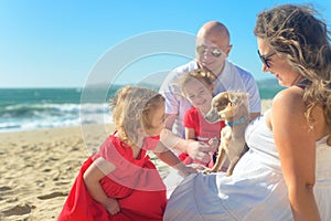 Family with sisters in red dress and dog on the beach