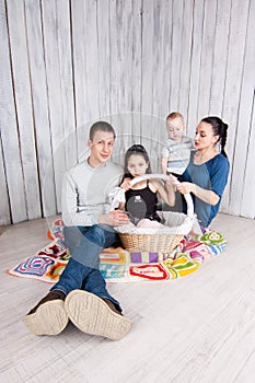 Family sit on the floor with basket.