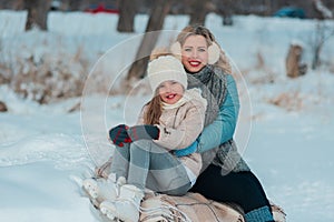 Family sits on a bench on the shore of a frozen lake