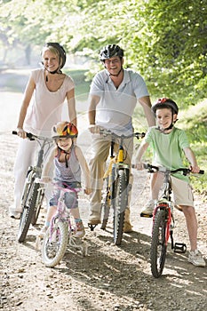La famiglia seduti sulla bici su percorso di sorridere alla telecamera.