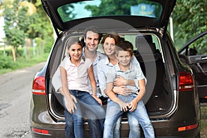 Family sitting in car trunk ready to go