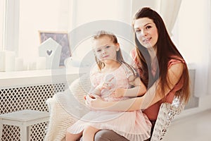 Family sitting on chair at home. Casual lifestyle capture of mother and toddler daughter
