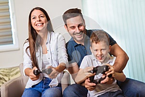 Family sitting on the couch together playing video games