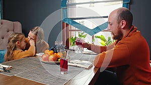 A family sitting in the hotel restaurant - drinking juice and talking - mother and daughter hugging each other