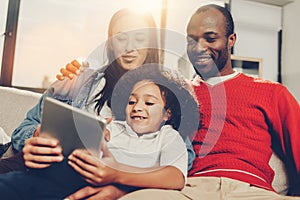 Family sitting indoors and enjoying modern technology