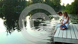 Family sitting on lake surrounded by green nature