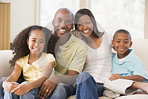 Family sitting in living room smiling