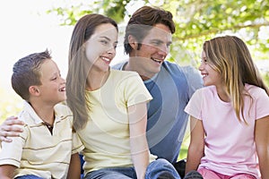 Family sitting outdoors smiling