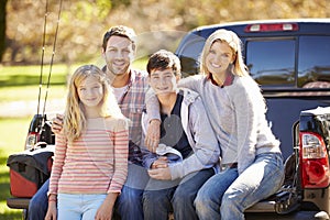 Family Sitting In Pick Up Truck On Camping Holiday