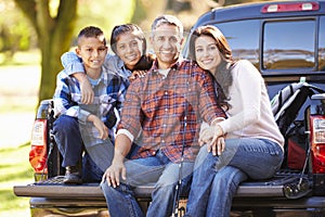 Family Sitting In Pick Up Truck On Camping Holiday photo
