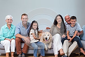 Family sitting on sofa with dog