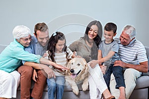 Family sitting on sofa with dog