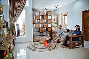 Family Sitting On Sofa At Home Watching TV Together