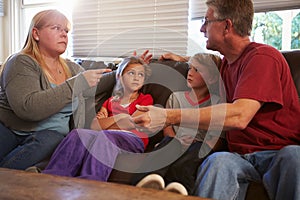 Family Sitting On Sofa With Parents Arguing