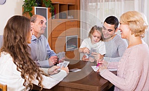 Family sitting at table with cards