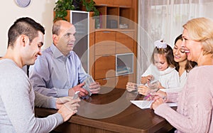 Family sitting at table with cards