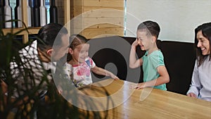 Family sitting table together in a cafe