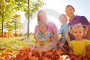 Family sitting together on leaves in the park