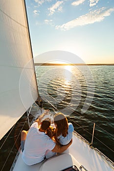 Family Sitting On Yacht Deck Back To Camera, Vertical