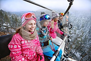 Family in ski lift going to ski terrain