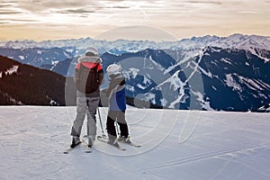 Family, skiing in winter ski resort on a sunny day, enjoying landscape