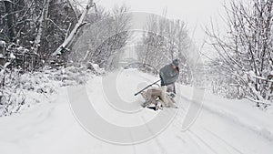 family sledding in winter. outdoor winter activity. Happy, laughing family, woman with 2 daughters are enjoying of