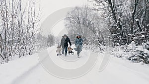 family sledding in winter. outdoor winter activity. Happy, laughing, playful family of 4 is enjoying of sledging their