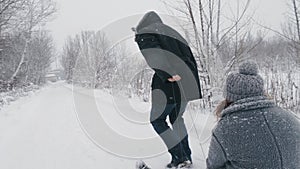 family sledding in winter. outdoor winter activity. Happy, laughing, playful married couple is enjoying of sledging on