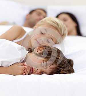 Family sleepimg in parent's bed
