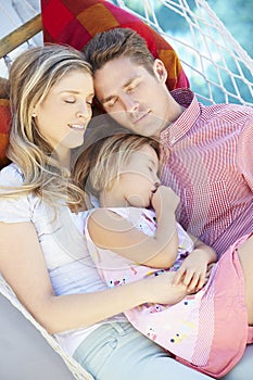 Family Sleeping In Garden Hammock Together