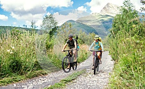 Family with small children cycling outdoors in summer nature.