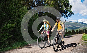 Rodina s malými deťmi na bicykli vonku v letnej prírode, Vysoké Tatry na Slovensku.