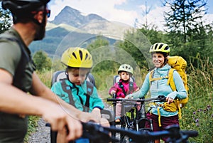 Family with small children cycling outdoors in summer nature, Tatra mountains Slovakia.