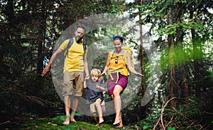 Family with small children walking barefoot outdoors in summer nature.