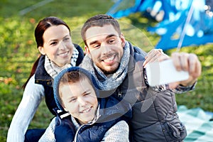 Family with smartphone taking selfie at campsite