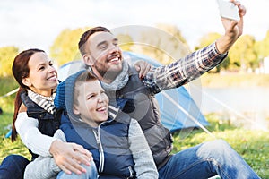 Family with smartphone taking selfie at campsite