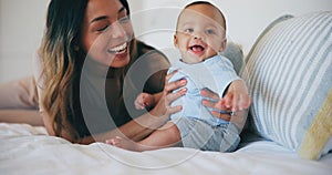 Family, smile and a mother on the bed with her baby in their home together for care or bonding. Children, love and a