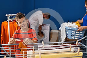 Family smiling confident doing laundry at laundry room