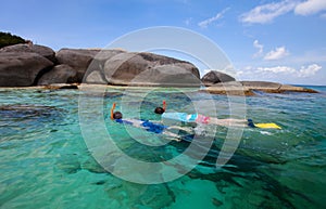 Family snorkeling at tropical water