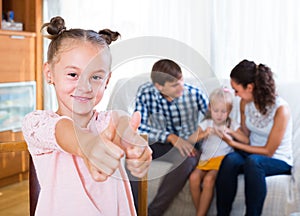 Family on sofa, girl standing apart