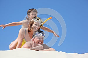 Family with son on sand with snorkeling mask