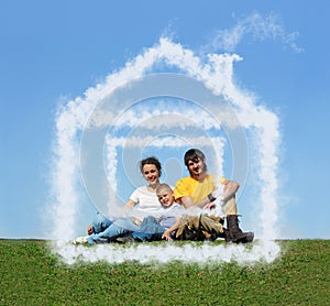 Family with son sitting cloud house on meadow