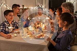 Family with sparklers having dinner party at home