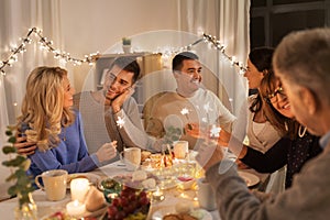 Family with sparklers having dinner party at home