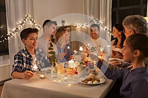 Family with sparklers having dinner party at home