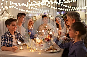 Family with sparklers having dinner party at home