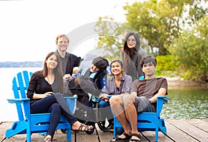 Family with special needs child sitting outdoors together in sum photo