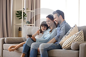 Family spend free time watching cartoons on mobile phone photo