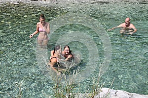 Family spending time together in a crystalclear water of river